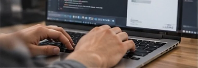 Hands typing on a laptop showing code and dashboards